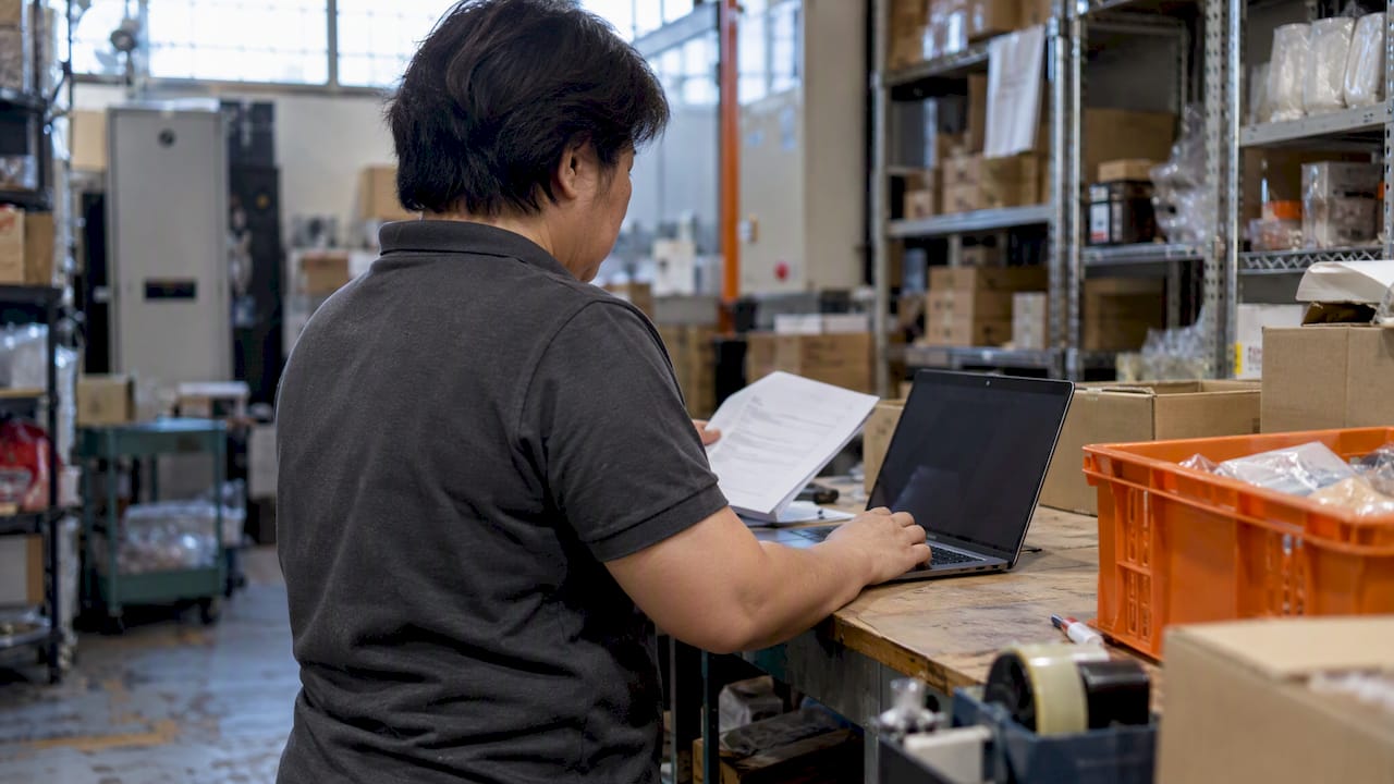 Shop owner checking invoice against stock records
